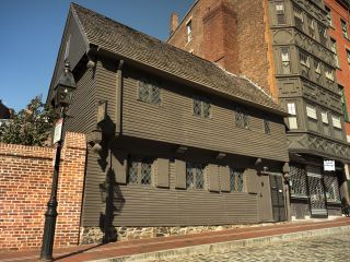 A Large Brick Building With Paul Revere House In The Background